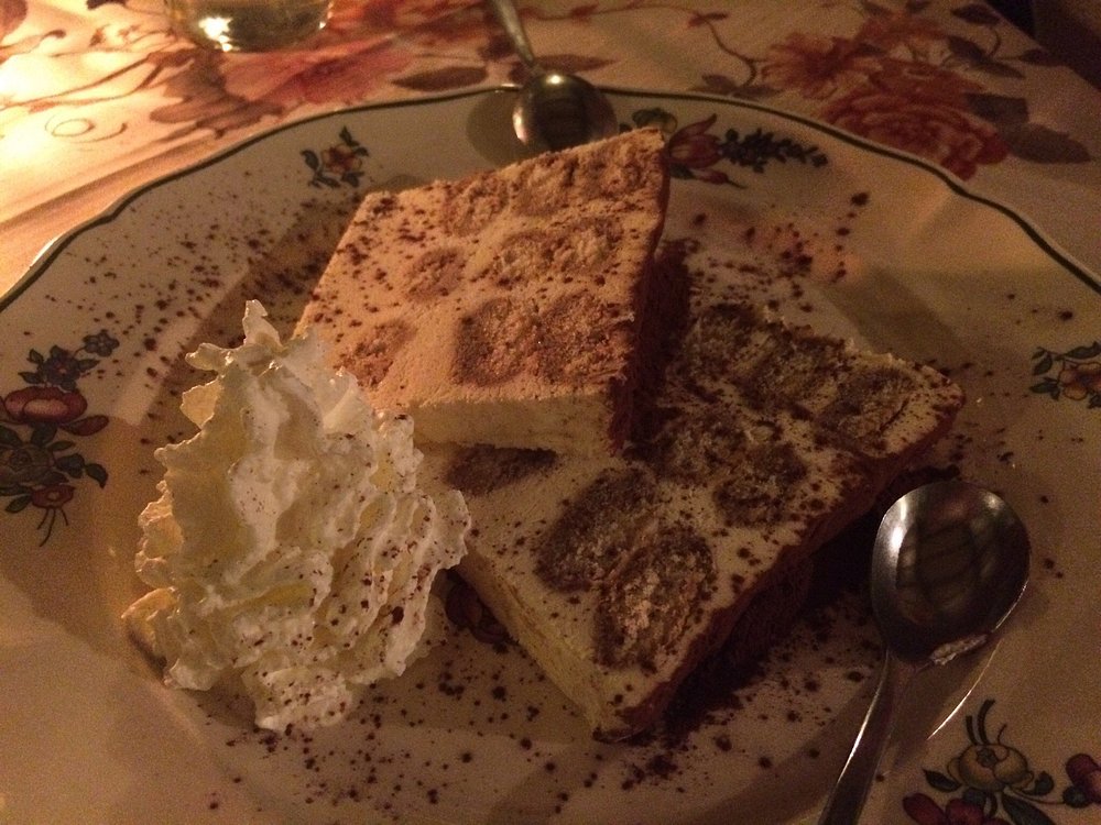 Hausgemachtes Tiramisu mit Sahne und Kakao auf Vintage-Teller mit Blumenrand